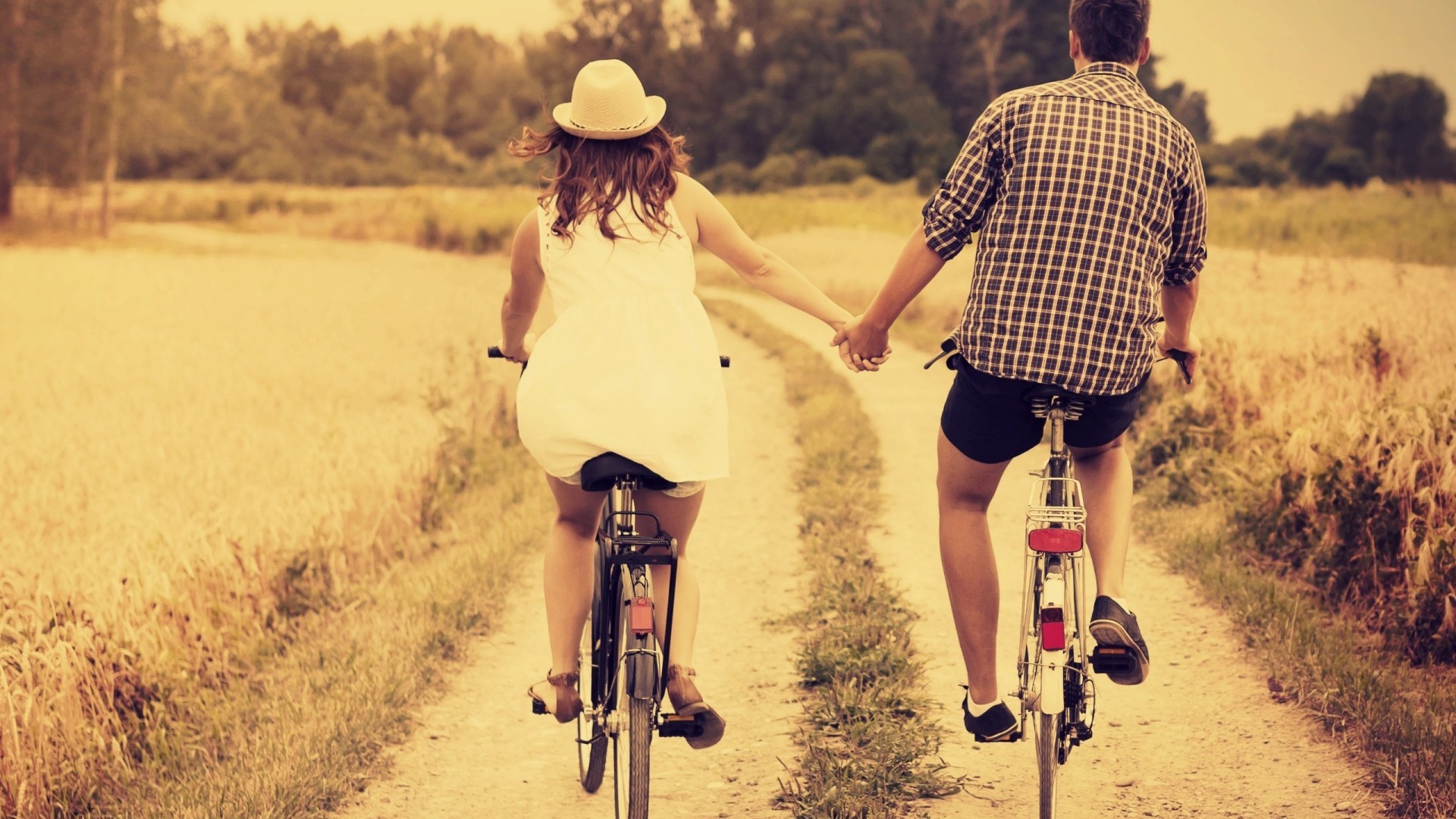 在黄昏下骑着自行车的情侣